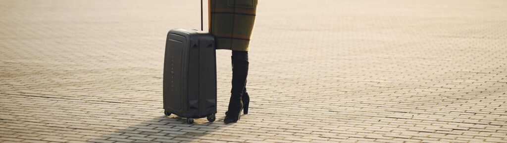 cheerful female tourist with suitcase