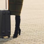 cheerful female tourist with suitcase